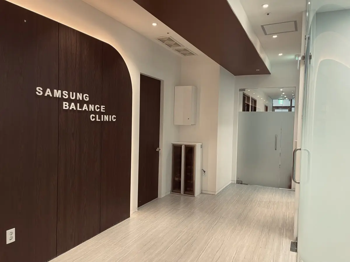 Modern hallway at Samsung Balance Clinic with wood paneling and frosted glass doors