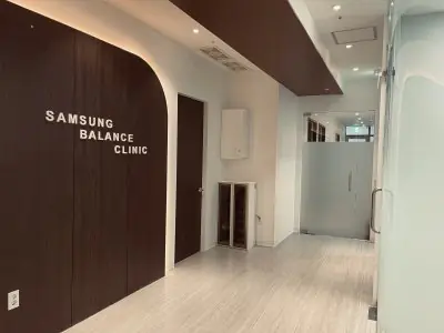 Pasillo moderno en Samsung Balance Clinic con paneles de madera y puertas de vidrio esmerilado