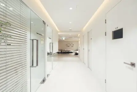 Pasillo moderno de la clínica INIQUE con puertas de vidrio y sala de espera