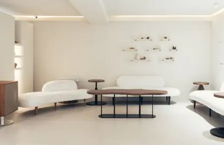 Sala de espera de la clínica INIQUE con sofás blancos modernos y decoración minimalista
