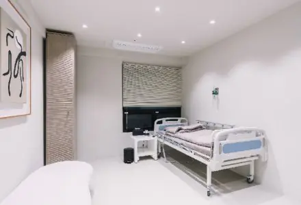 Habitación de paciente en la clínica INIQUE con cama hospitalaria y diseño minimalista moderno