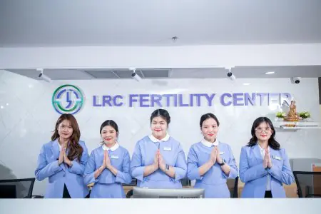 موظفو الاستقبال في عيادة LRC Fertility Clinic يرتدون زيًا أزرق عند مكتب الاستقبال