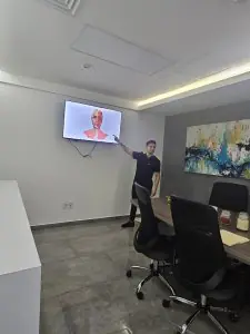 Sala de consulta en Dr. Irwin Abad Medicina Estética y Regenerativa con pantalla anatómica