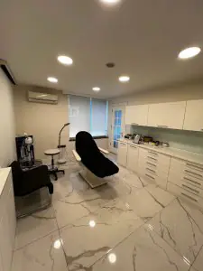 Sala de tratamiento moderna en Mert Meral Clinic con silla médica y equipo