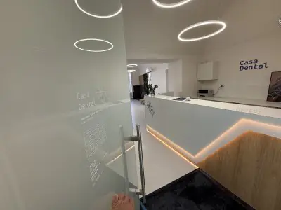 Área de recepción en Casa Dental Clinic con diseño moderno y mostrador iluminado