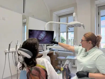 Dentista consulta al paciente con radiografía dental en pantalla en Casa Dental Clinic