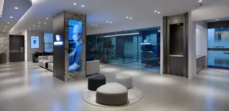 منطقة انتظار حديثة في عيادة Gangnam Brand Eye مع جدران زجاجية ومقاعد
