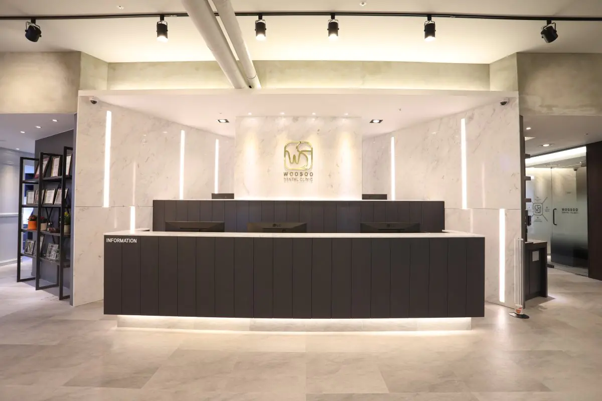 Mostrador de recepción en Woosoo Dental Clinic con interior moderno de mármol