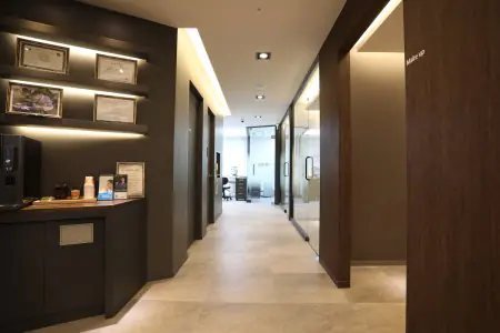 Pasillo moderno en Woosoo Dental Clinic con certificados y oficinas acristaladas