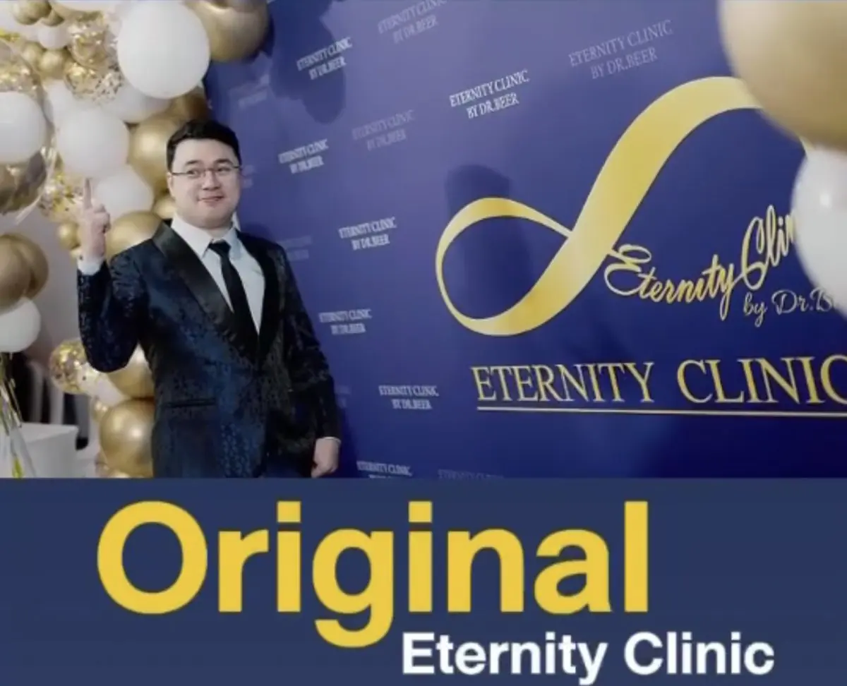Eternity Clinic Pleonchit event backdrop with branding and gold-white balloons