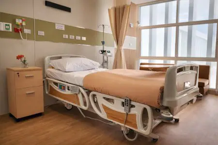 غرفة مريض في مستشفى LUX KOR بسرير حديث ونافذة كبيرة