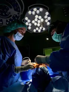 Equipo quirúrgico realizando operación bajo luces LED en quirófano de Klinika Promedion