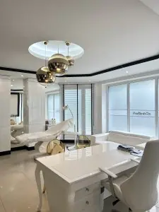 Sala de consultas en Klinika Promedion con mobiliario blanco moderno en Polonia