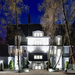 Fachada de la clínica Klinika Promedion de noche, entrada iluminada en Polonia