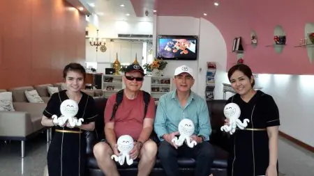 Área de recepción en Bangkok Dental Hospital, sala moderna con personal y pacientes