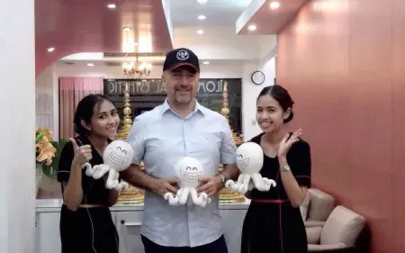Personal de recepción con paciente en Bangkok Dental Hospital Silom, ambiente acogedor