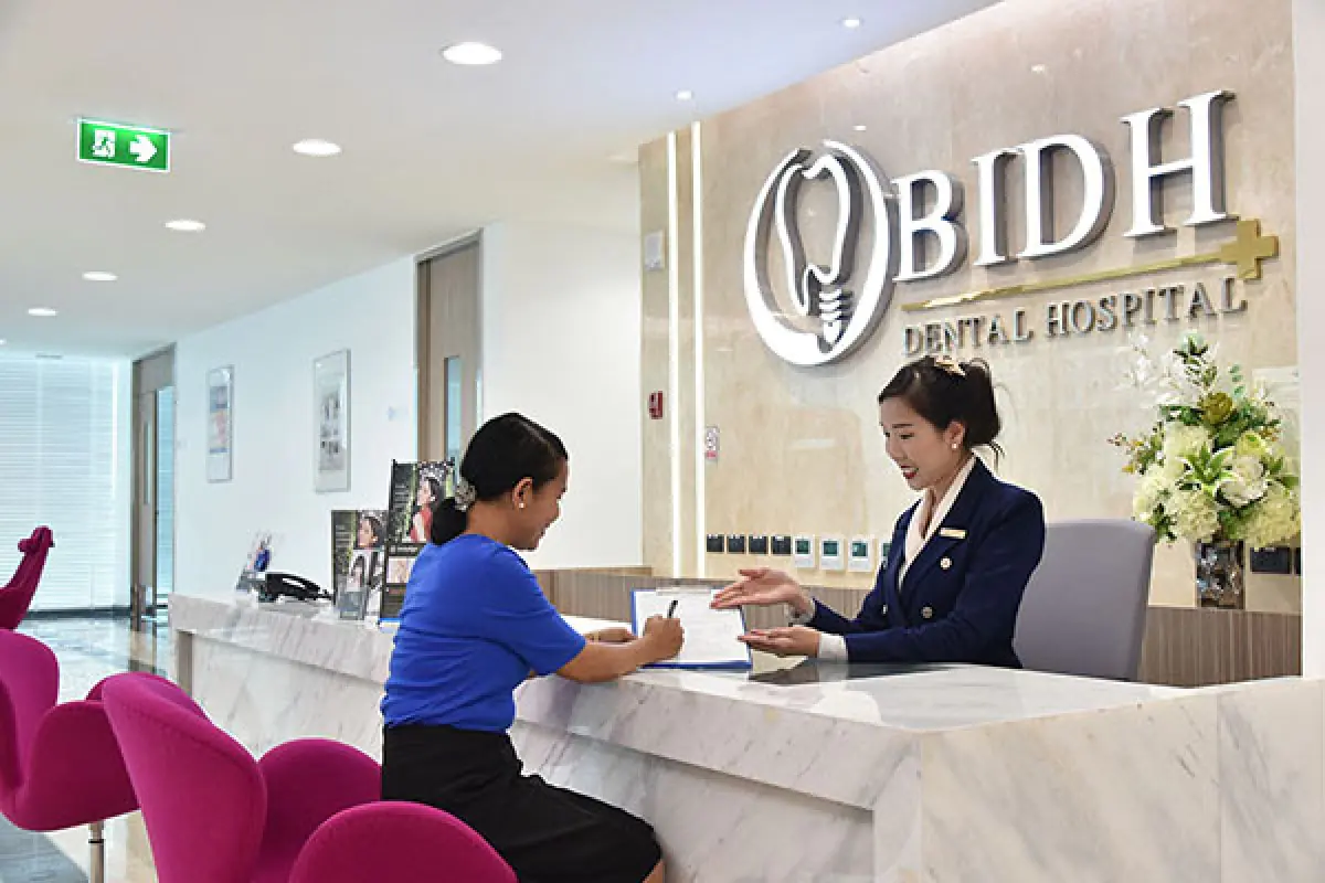 Reception area at Bangkok Dental International Hospital with staff assisting patient