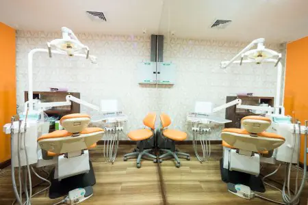 غرفة علاج أسنان حديثة في Siam Station Dental Clinic بكراسي برتقالية