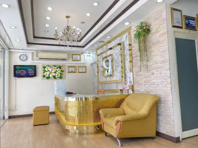 Área de recepción en Central Pattaya Dental Center con decoración moderna y detalles dorados