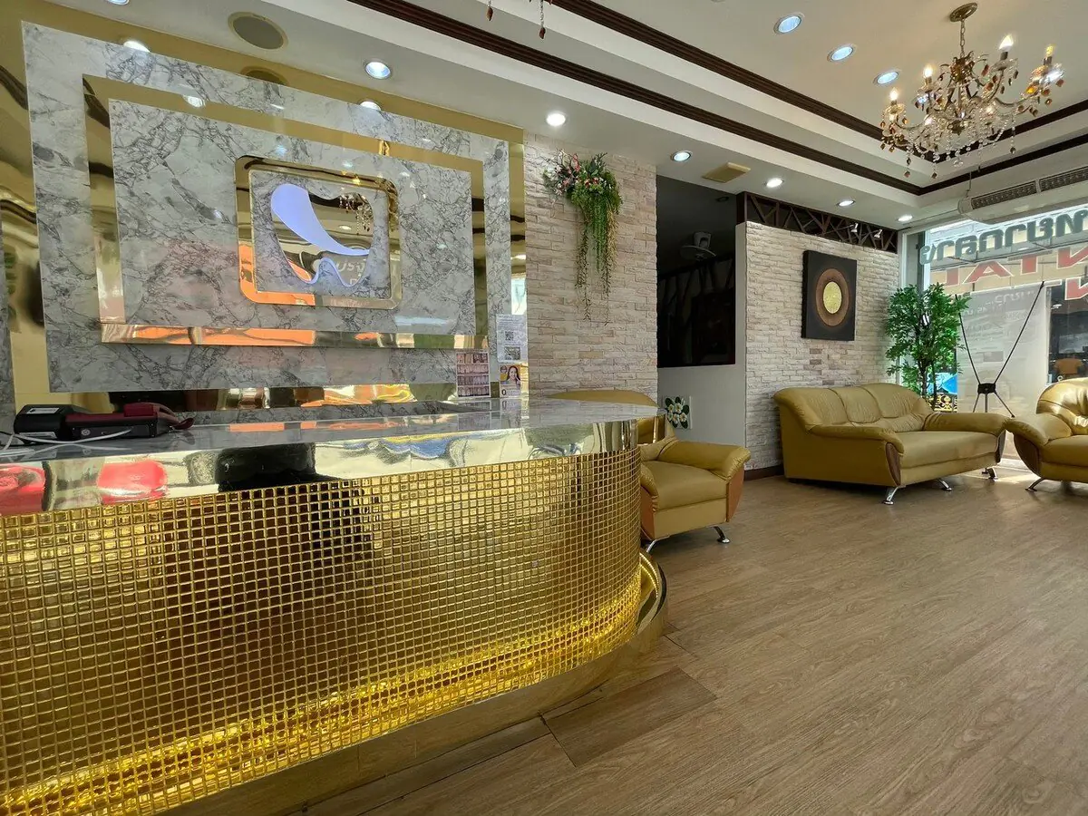 Recepción en Central Pattaya Dental Center con decoración dorada y sala de espera