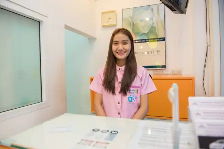 مكتب استقبال في عيادة Pattaya Smile Dental مع موظفة بالزي الرسمي