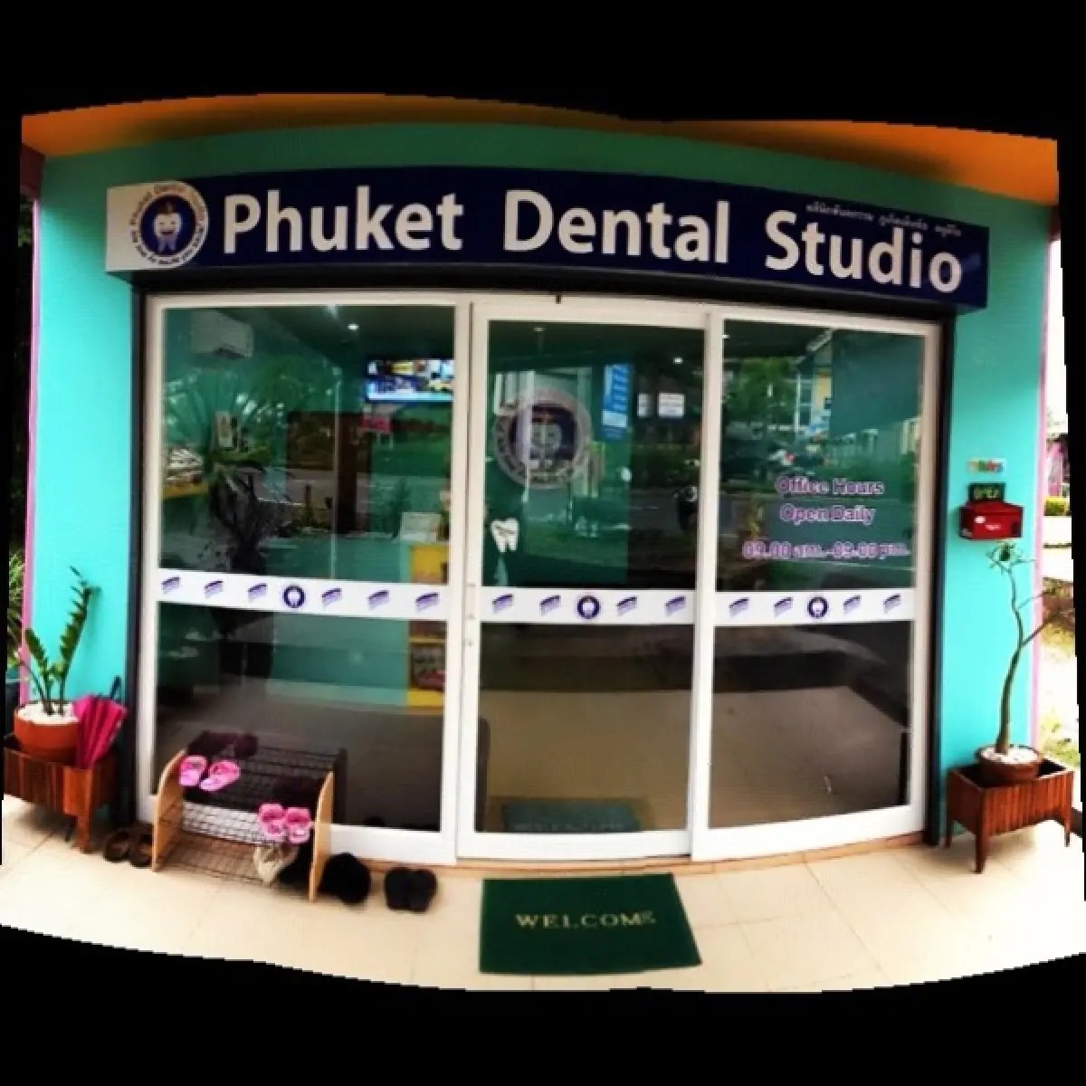 مدخل عيادة Phuket Dental Studio في تايلاند بأبواب زجاجية وسجادة ترحيب