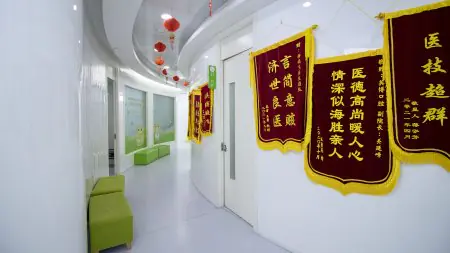 Pasillo luminoso en Shanghai Y+bo Dental Clinic con pancartas y asientos verdes