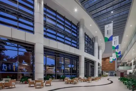 ردهة واسعة في مركز Boao International Medical Center بمقاعد حديثة وجدران زجاجية