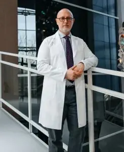 Médico con bata blanca en pasillo moderno de la clínica Volodymyr Sazhiyenko