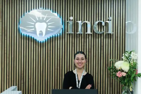 مكتب استقبال في عيادة Inci Dis International Dental Clinic مع موظف وزهور