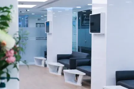 منطقة انتظار حديثة في عيادة Inci Dis International Dental Clinic مع أرائك وجدران زجاجية