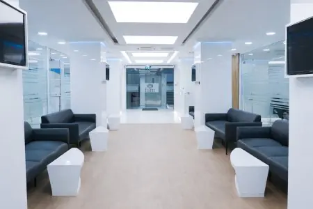 منطقة انتظار حديثة في عيادة Inci Dis International Dental Clinic مع أرائك وجدران زجاجية