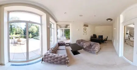 Sala de recepción en Zeus Detox & Rehab Center con vista al jardín y mobiliario moderno