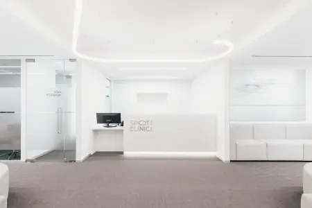 Área de recepción en Spot Clinic con interior blanco moderno y zona de espera