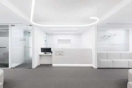 Área de recepción en Spot Clinic con interior blanco moderno y zona de espera