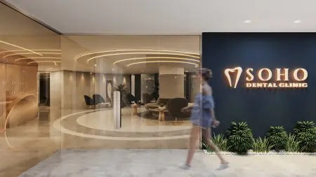 Entrada moderna y recepción en Soho Dental Clinic con letrero iluminado