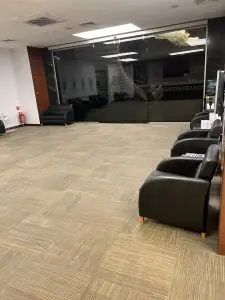 Amplia sala de espera con sofás negros en la clínica Dr. Tolgay Şatana