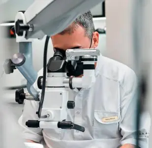 طبيب أسنان يستخدم مجهرًا في عيادة YAREMA DENTAL