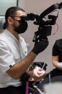 طبيب أسنان يستخدم المجهر في عيادة YAREMA DENTAL أثناء علاج المريض
