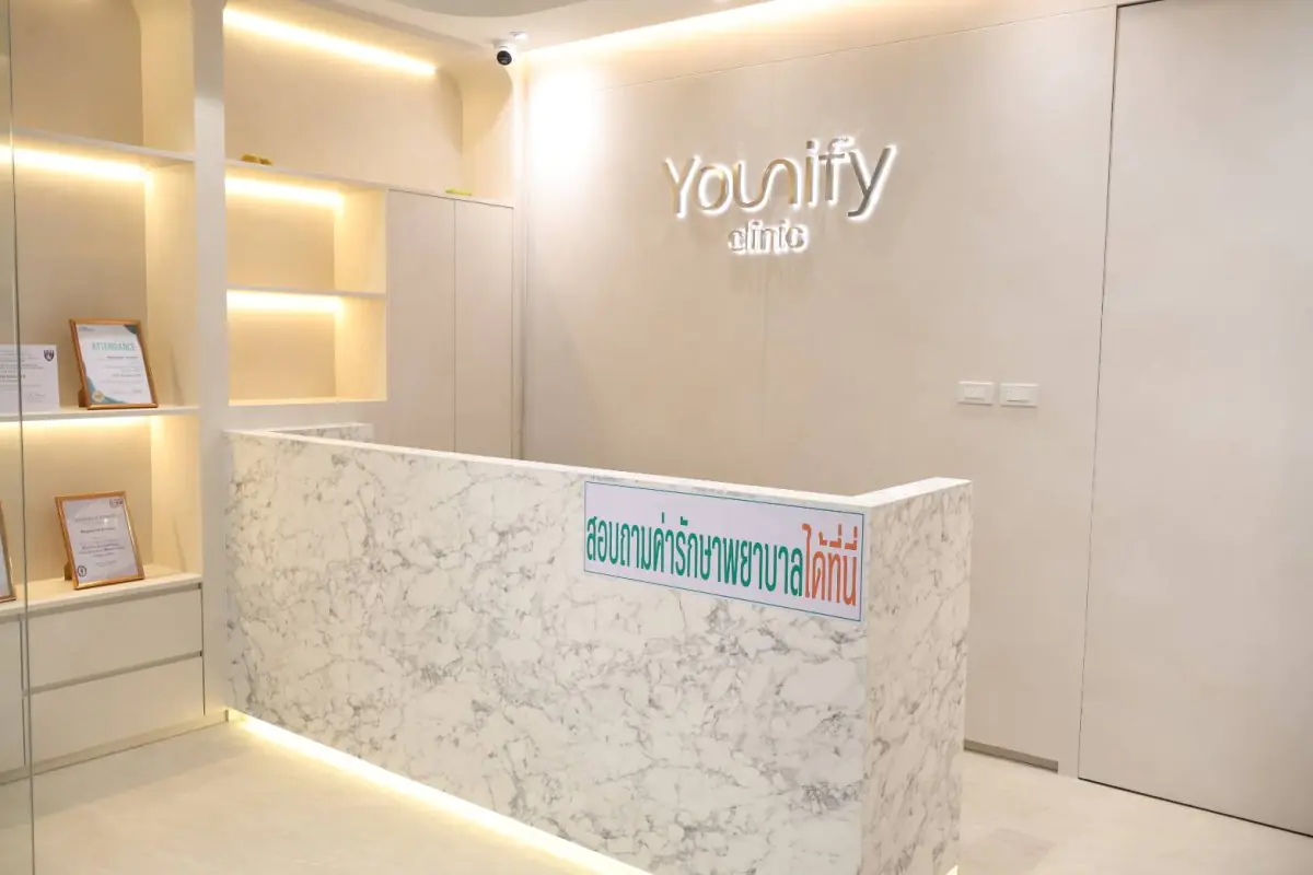 Empfangstresen der YOUNIFY Clinic mit modernem Marmordesign und ausgestellten Zertifikaten