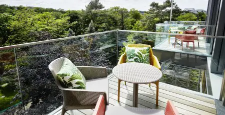 Terraza exterior en la clínica Rudolfinerhaus con vista al jardín y asientos modernos