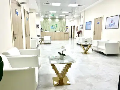 Sala de espera moderna en Best Life Fertility Centre con asientos blancos y recepción