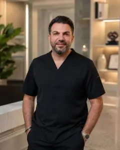 Médico con uniforme negro en el interior de la clínica Zülfü Sertkaya Men's Health and Aesthetics