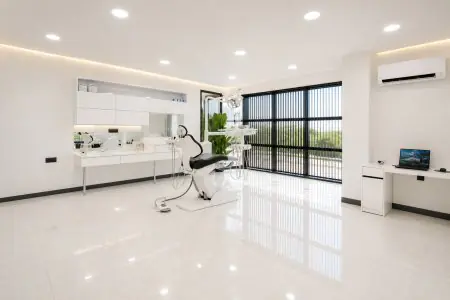 غرفة علاج أسنان حديثة في Lo Smiles UK Ltd مع معدات متقدمة ونوافذ كبيرة