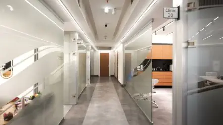 ممر حديث في عيادة Positive Dental Studio مع فواصل زجاجية وغرف علاج