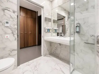 Baño moderno para pacientes en la clínica Rudolfinerhaus con paredes de mármol y ducha accesible