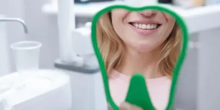 مريضة تبتسم بعد علاج الأسنان في غرفة طب الأسنان في Zaren Clinic
