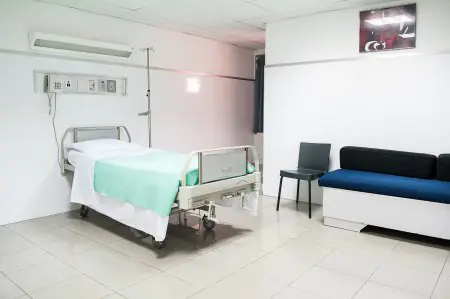 غرفة مرضى في New City Clinic بسرير مستشفى ومنطقة جلوس
