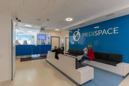 Recepción y sala de espera en la clínica MediSpace con asientos modernos y decoración azul