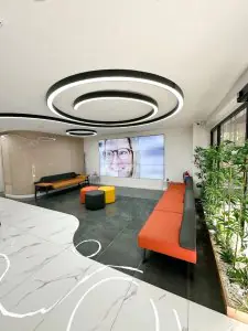 منطقة انتظار حديثة في EB Dental Clinic بمقاعد أنيقة وشاشة رقمية